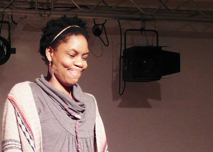 Monolog: Lächelnde farbige Frau blickt nach schräg unten