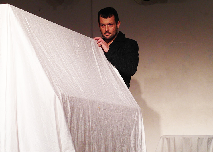 Monolog: Mann blickt konzentriert auf weisses Tuch vor sich